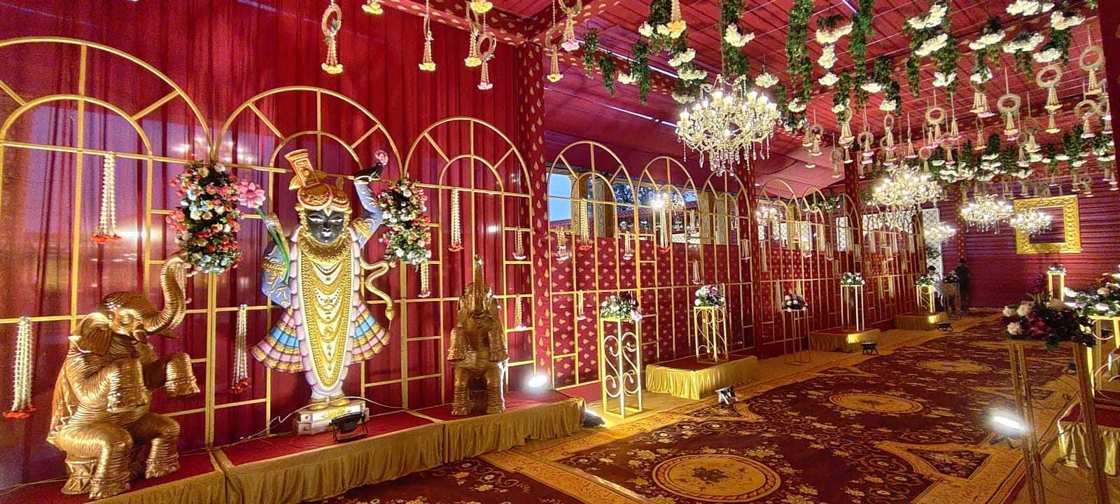 Red and gold wedding corridor with floral arches