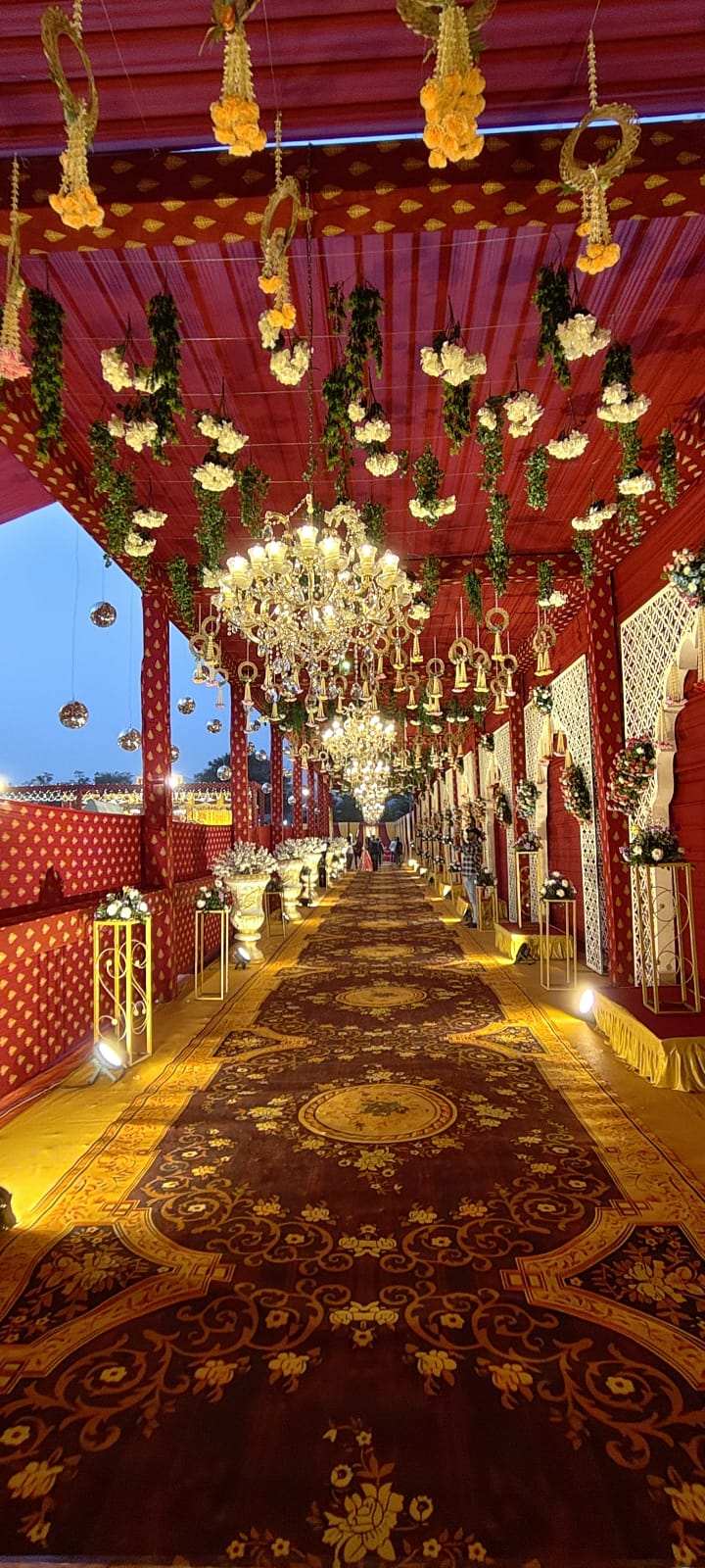 Red and gold wedding corridor with chandeliers